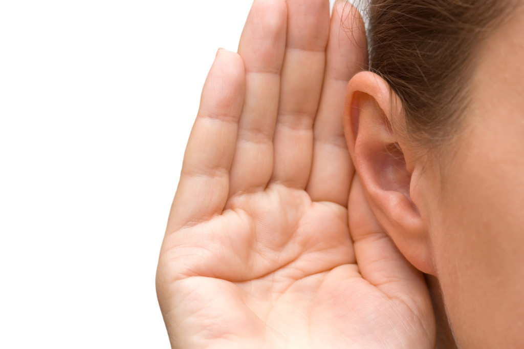 Girl listening with her hand on an ear